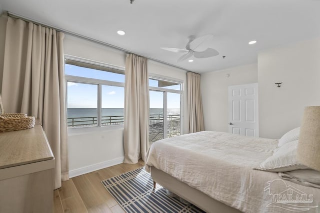 bedroom with a water view, ceiling fan, access to outside, and multiple windows