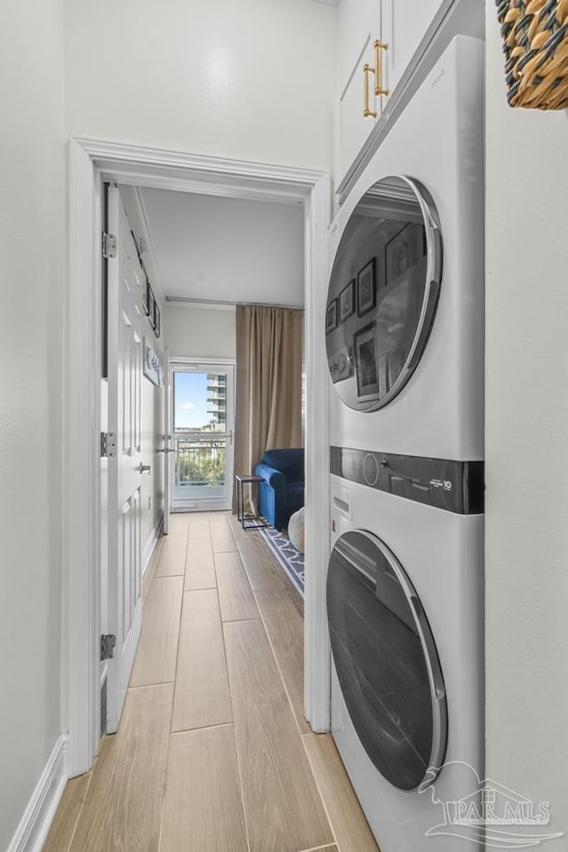 clothes washing area featuring stacked washer and clothes dryer