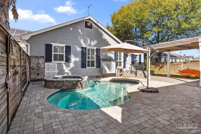 rear view of house featuring a swimming pool with hot tub and a patio