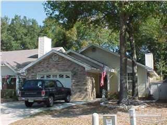 3130 Station Ct, Pensacola, FL 32504 - view of front facade featuring a chimney, concrete driveway, and an attached garage