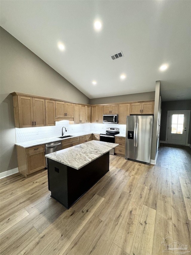 kitchen featuring sink, light hardwood / wood-style flooring, a center island, and appliances with stainless steel finishes