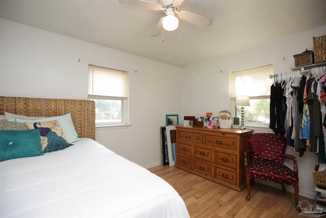 bedroom with multiple windows, light hardwood / wood-style flooring, and ceiling fan