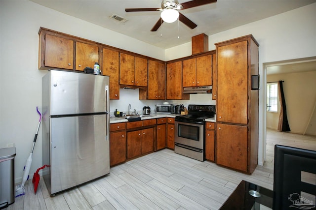 kitchen featuring stainless steel appliances, ceiling fan, light hardwood / wood-style floors, and sink