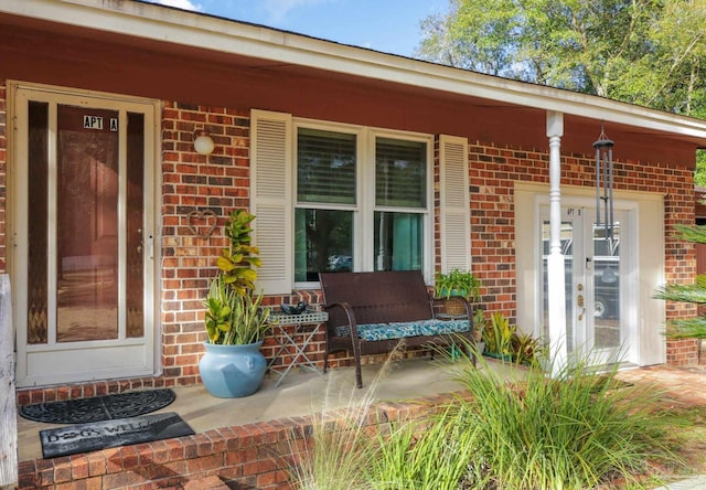 entrance to property featuring a porch and french doors