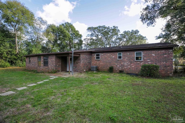 rear view of property with a lawn and cooling unit