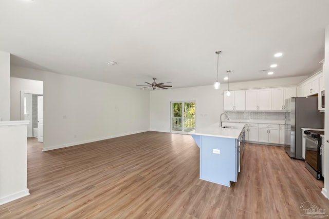 kitchen with black range with electric stovetop, decorative backsplash, open floor plan, white cabinetry, and light wood-type flooring