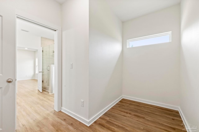 hallway with baseboards and light wood-style floors