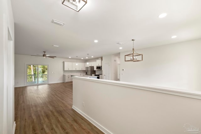 interior space featuring recessed lighting, a sink, wood finished floors, baseboards, and visible vents