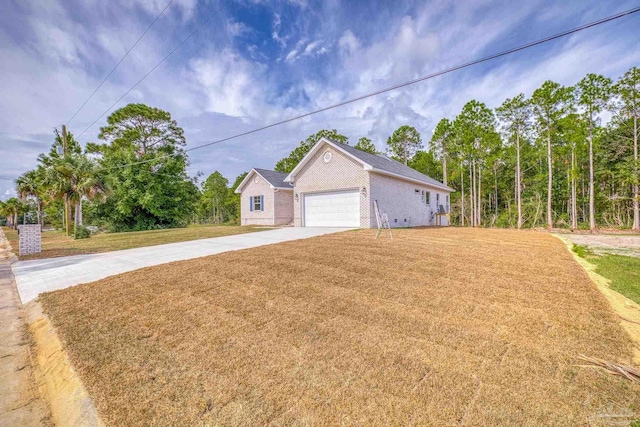 view of front of home featuring a garage, concrete driveway, a front lawn, and brick siding