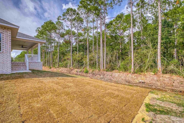 view of yard with covered porch and ceiling fan