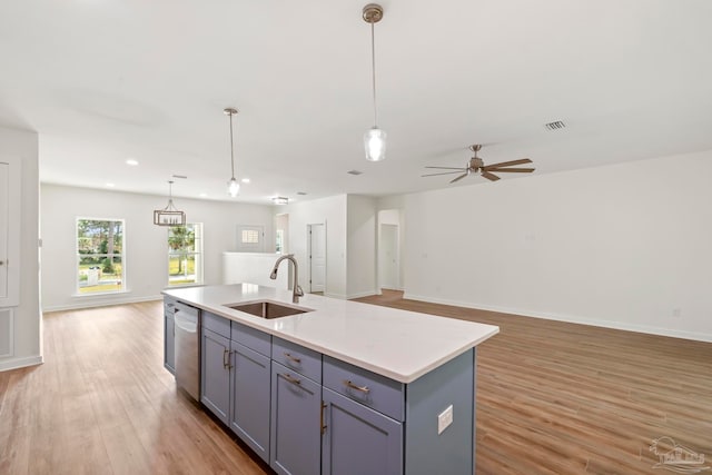 kitchen featuring light wood-type flooring, open floor plan, a sink, and gray cabinetry