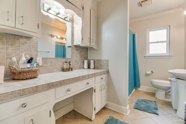 4551 Creighton Rd, Pensacola, FL 32504 - bathroom featuring tasteful backsplash, toilet, ornamental molding, vanity, and tile patterned flooring