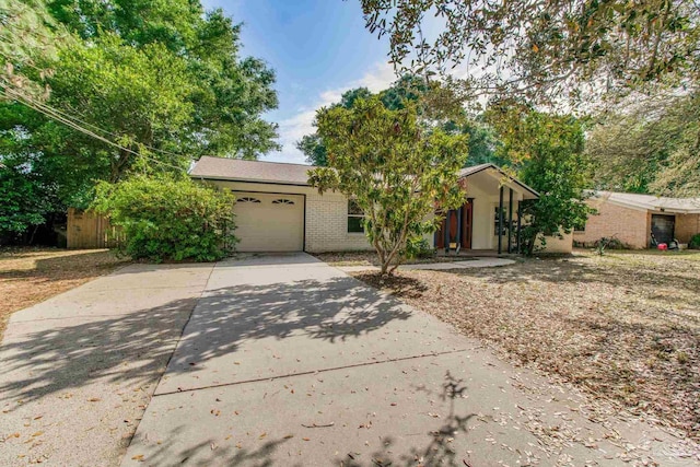 4551 Creighton Rd, Pensacola, FL 32504 - view of front of property with a garage, brick siding, fence, and concrete driveway