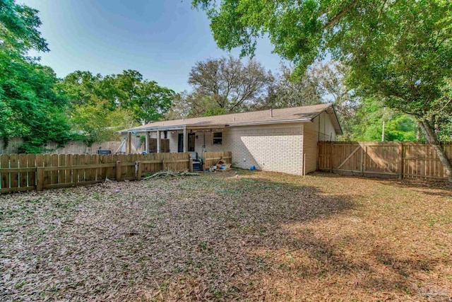 4551 Creighton Rd, Pensacola, FL 32504 - rear view of house featuring a gate, brick siding, and a fenced backyard