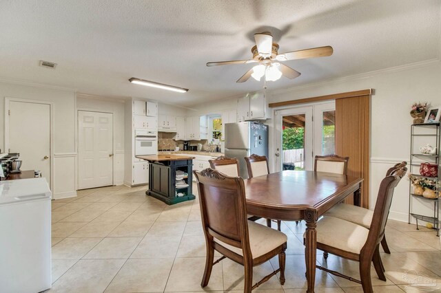 4551 Creighton Rd, Pensacola, FL 32504 - dining room with light tile patterned floors, ornamental molding, visible vents, a ceiling fan, and french doors
