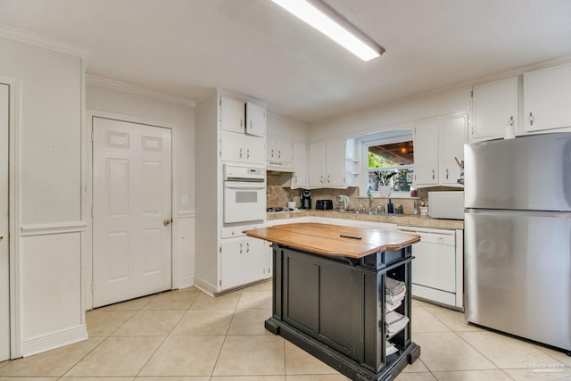 4551 Creighton Rd, Pensacola, FL 32504 - kitchen with white cabinetry, light tile patterned floors, white appliances, and under cabinet range hood