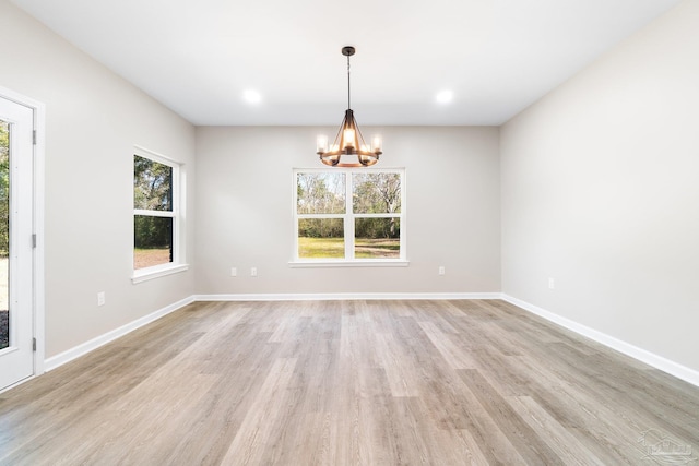 empty room featuring light hardwood / wood-style floors and an inviting chandelier