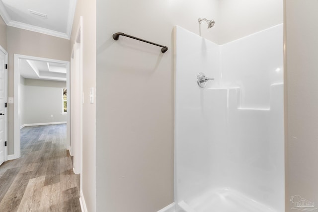 bathroom with ornamental molding, hardwood / wood-style floors, and walk in shower