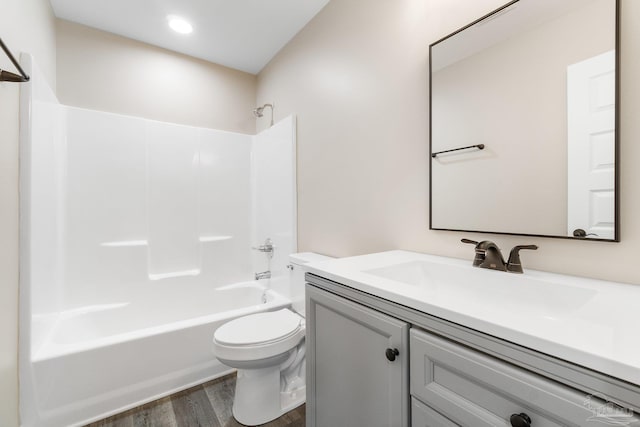 full bathroom with hardwood / wood-style floors, vanity,  shower combination, and toilet