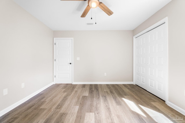 unfurnished bedroom featuring ceiling fan, light wood-type flooring, and a closet