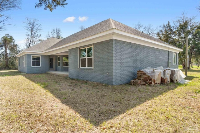 rear view of property featuring a patio and a lawn