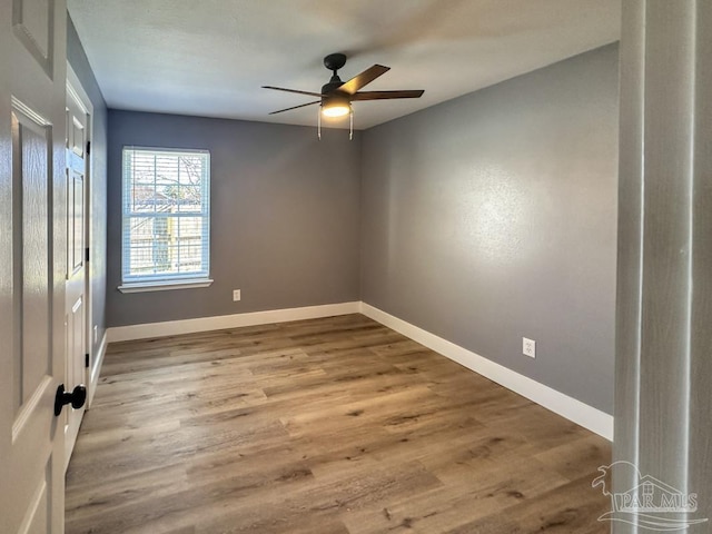 empty room with ceiling fan and wood-type flooring