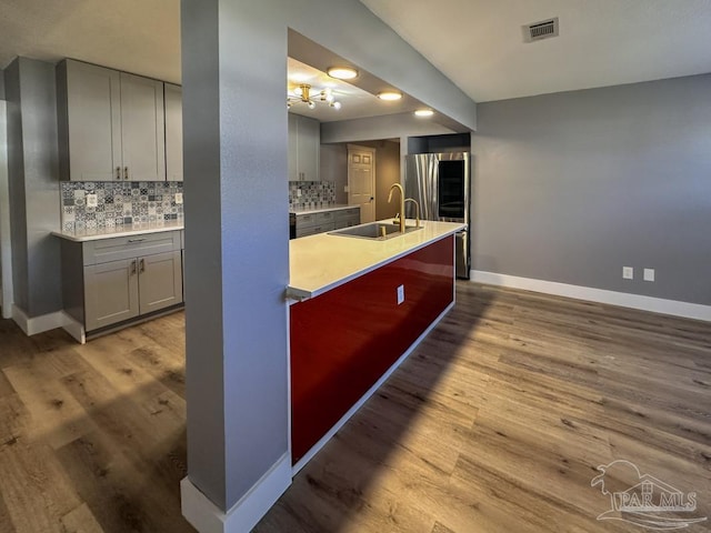 kitchen with decorative backsplash, gray cabinets, and sink