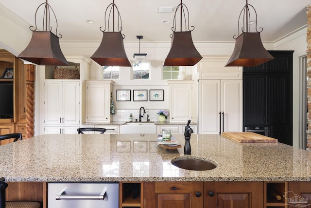 9 N Sunset Blvd, Gulf Breeze, FL 32561 - kitchen with a kitchen island with sink, open shelves, light stone counters, pendant lighting, and ornamental molding