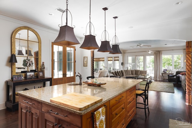 9 N Sunset Blvd, Gulf Breeze, FL 32561 - kitchen featuring dark wood finished floors, recessed lighting, open floor plan, light stone countertops, and hanging light fixtures