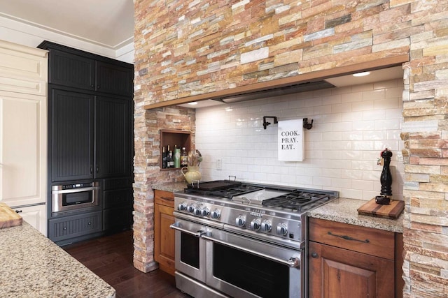 9 N Sunset Blvd, Gulf Breeze, FL 32561 - kitchen featuring range with two ovens, dark wood finished floors, light stone counters, and decorative backsplash