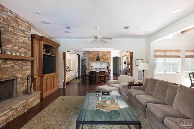 9 N Sunset Blvd, Gulf Breeze, FL 32561 - living area with arched walkways, ceiling fan, a fireplace, dark wood-type flooring, and ornamental molding