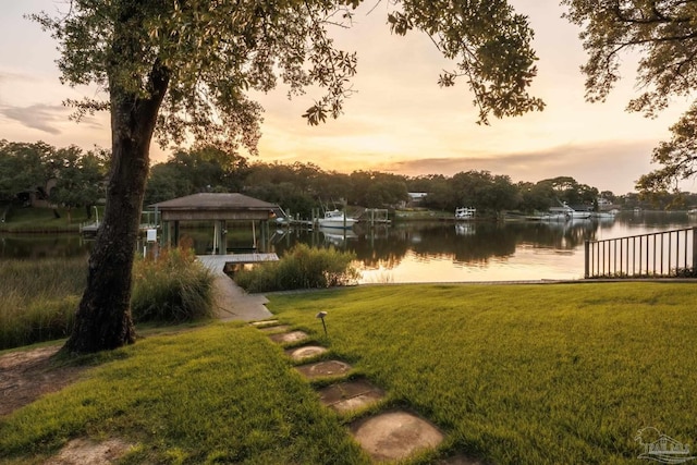 9 N Sunset Blvd, Gulf Breeze, FL 32561 - yard at dusk with a water view and a lawn