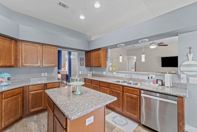 kitchen with visible vents, brown cabinets, a sink, a kitchen island, and dishwasher