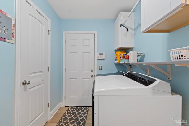 washroom featuring washer and clothes dryer, cabinet space, baseboards, and light tile patterned flooring