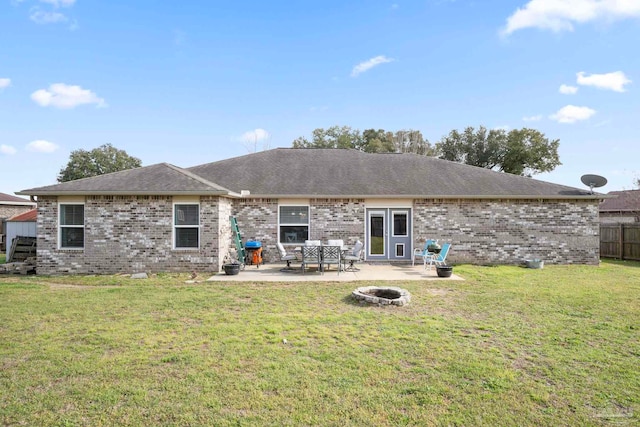 rear view of house featuring brick siding, fence, a patio area, and a lawn