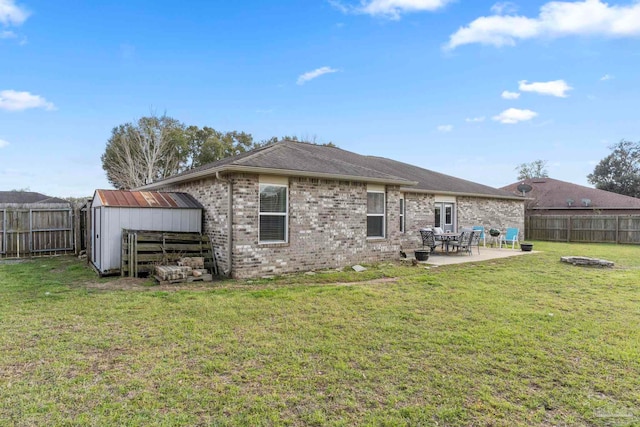 rear view of house with brick siding, a patio area, a lawn, and a fenced backyard