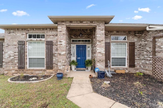 doorway to property featuring brick siding