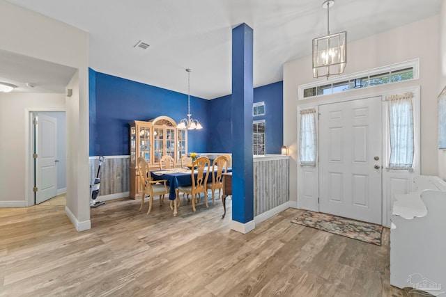 entryway featuring an inviting chandelier, wood finished floors, visible vents, and baseboards