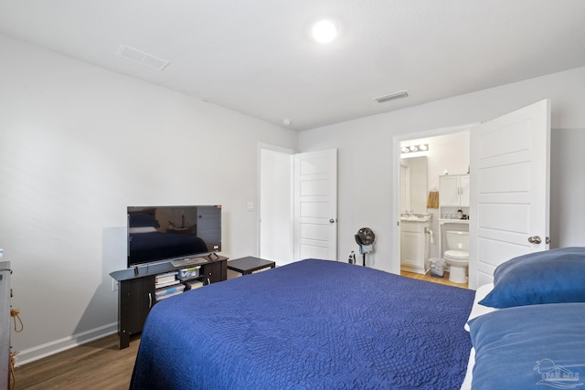 bedroom featuring dark hardwood / wood-style floors and connected bathroom