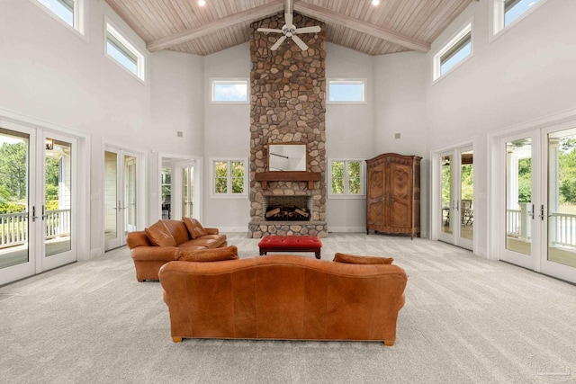 carpeted living room with a fireplace, ceiling fan, wooden ceiling, beam ceiling, and french doors