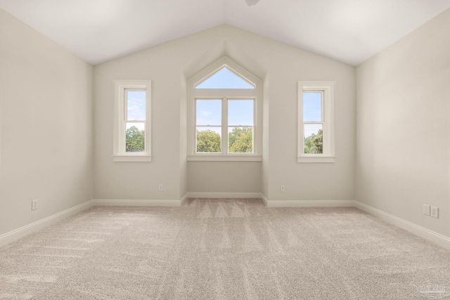 additional living space with lofted ceiling, a healthy amount of sunlight, and light colored carpet