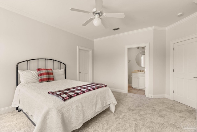 bedroom with crown molding, ensuite bath, light colored carpet, and ceiling fan