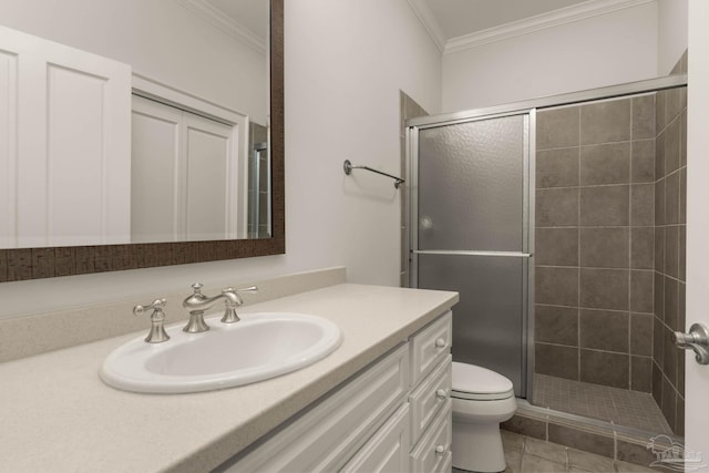 bathroom featuring vanity, a shower with shower door, ornamental molding, and toilet