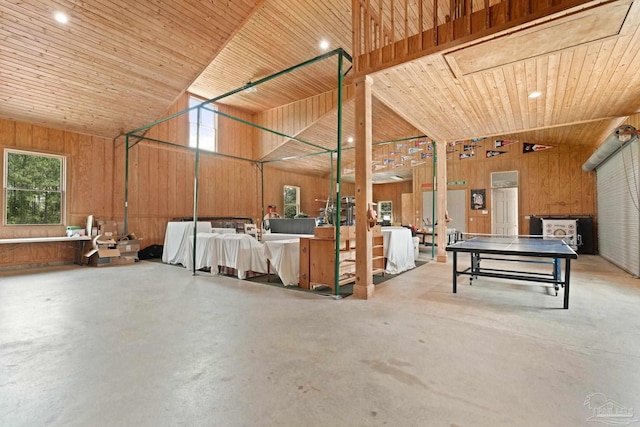 misc room with wood ceiling, high vaulted ceiling, concrete floors, and wood walls