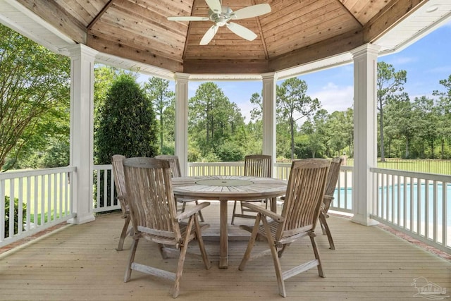 sunroom / solarium featuring lofted ceiling, wood ceiling, and ceiling fan