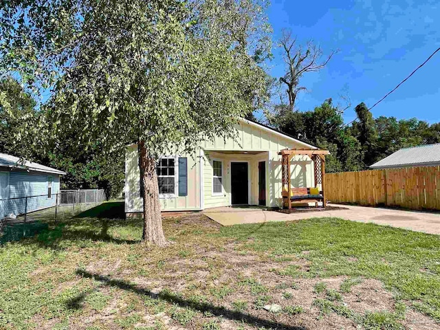 back of property with a patio area and a yard