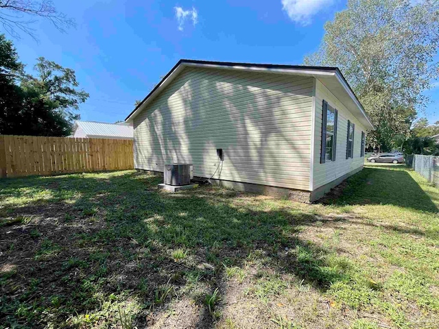 rear view of property with cooling unit and a yard