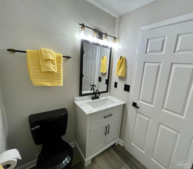 bathroom featuring vanity, toilet, and hardwood / wood-style floors