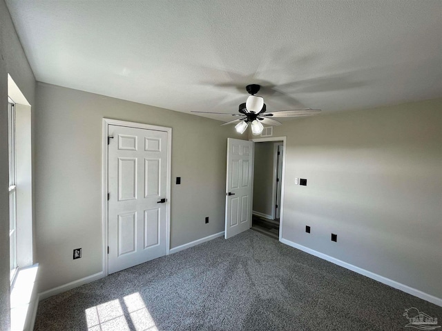 unfurnished bedroom featuring carpet, a textured ceiling, and ceiling fan