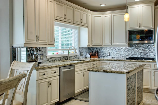 kitchen featuring appliances with stainless steel finishes, backsplash, sink, light stone counters, and pendant lighting